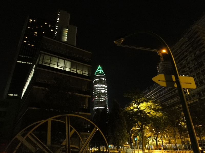 Pyramidenspitze des Messeturms in Frankfurt leuchtet grün