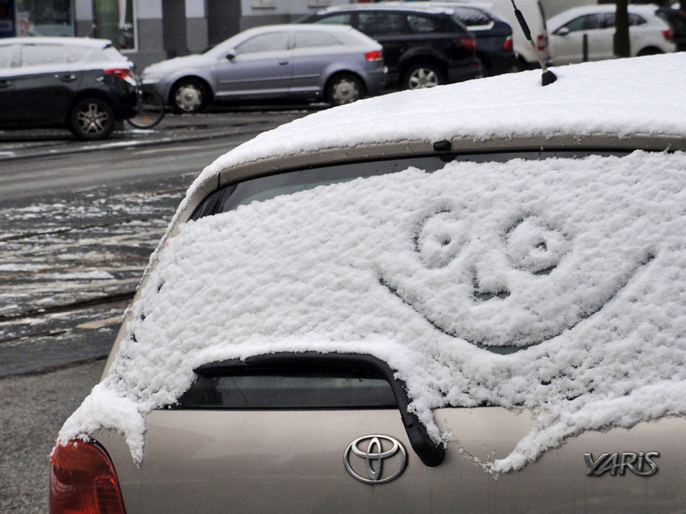 Schnee in Frankfurt 2016 - Gesicht mit Lächeln auf einer verschneiten Autoscheibe