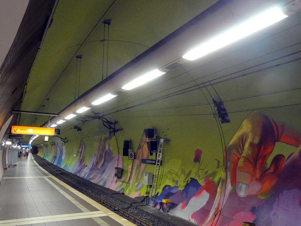 Laufende Hände an den Tunnelwänden in der Frankfurter S-Bahn-Station Ostendstraße von Andreas von Chrzaowski, Samira von Chrzaowski und Does