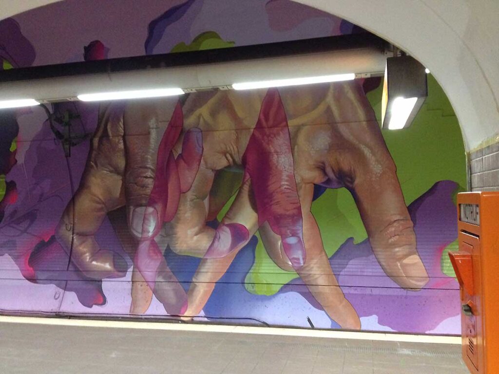 Laufende Hände an den Tunnelwänden in der Frankfurter S-Bahn-Station Ostendstraße von Andreas von Chrzaowski, Samira von Chrzaowski und Does