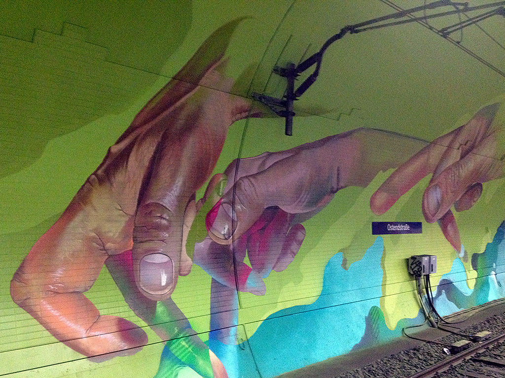 Laufende Hände an den Tunnelwänden in der Frankfurter S-Bahn-Station Ostendstraße von Andreas von Chrzaowski, Samira von Chrzaowski und Does