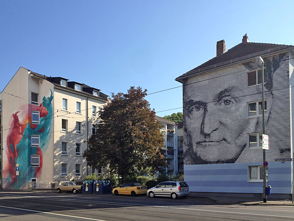 Graffiti-Hausfassade mit Bulle und Bär-Motiv in der Friedberger Landstraße
