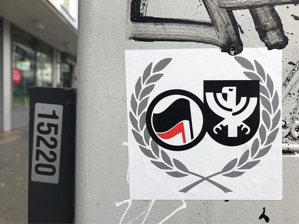 Aufkleber mit Leistikows Frankfurt-Adler und Antifa-Fahnen in Lorbeerkranz gefasst