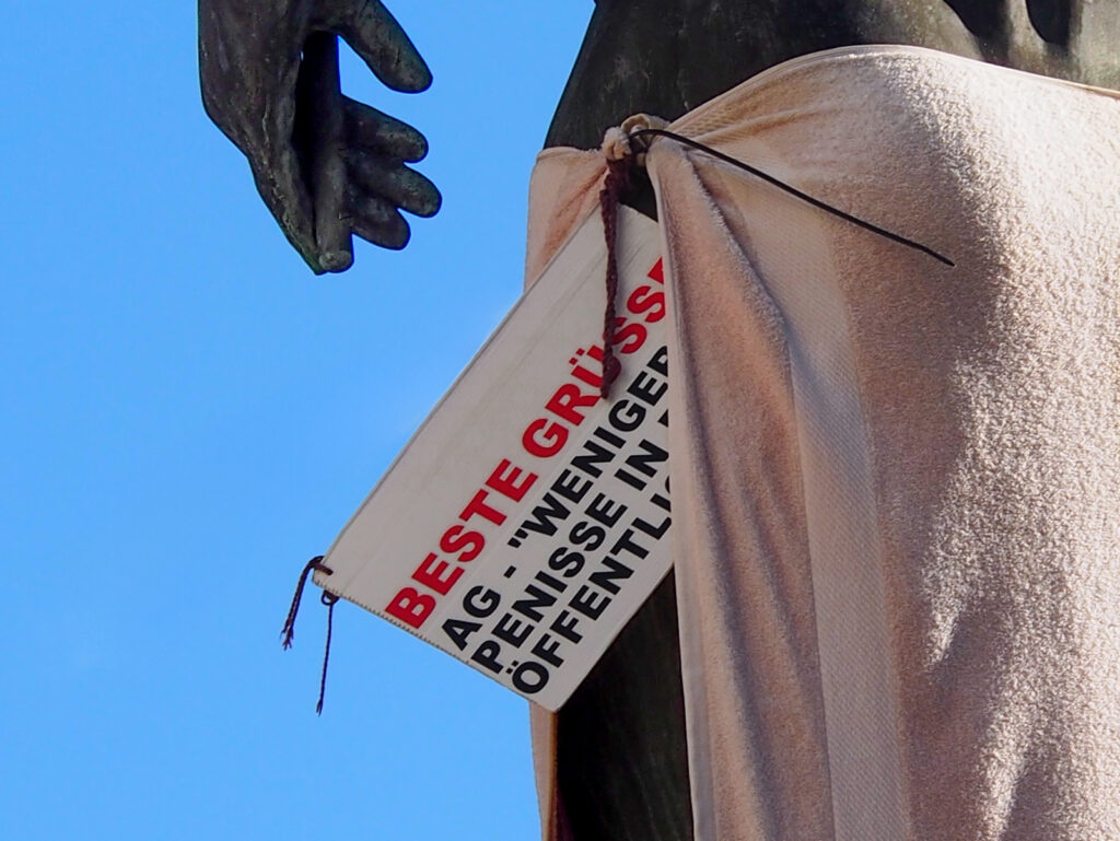Beste Grüsse – AG – "Weniger Penisse in der Öffentlichkeit" an Statue bei der HfG in Offenbach