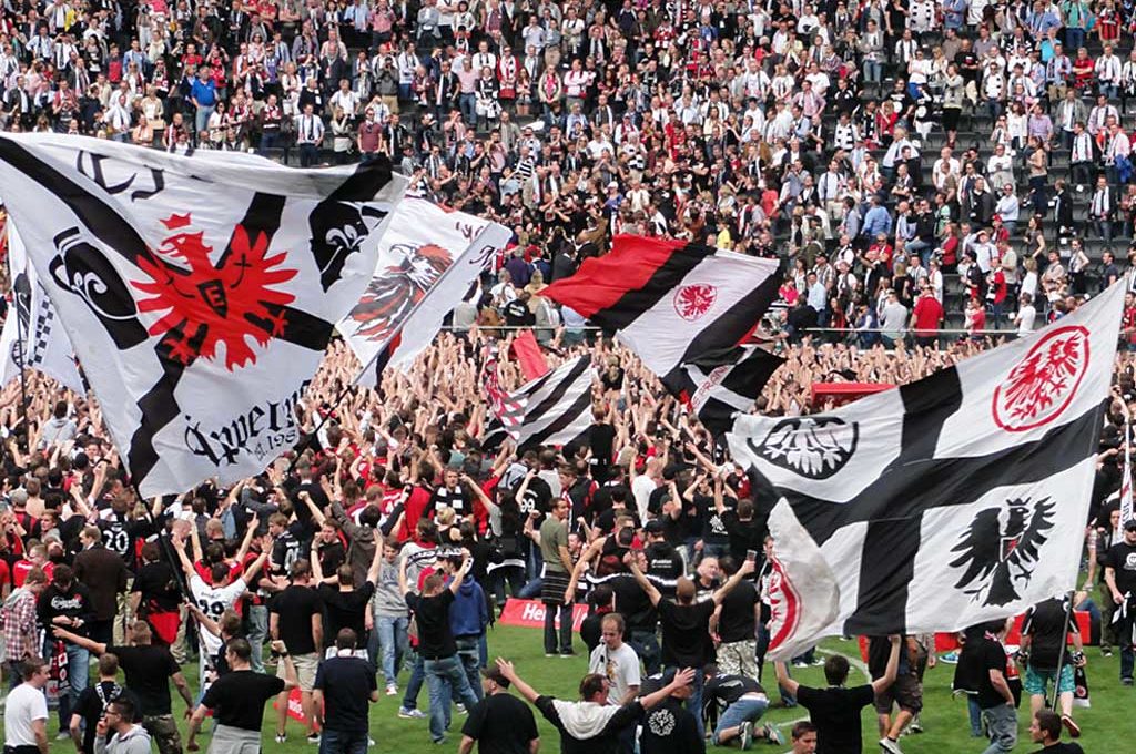Fans von Eintracht Frankfurt feiern auf dem Spielfeld