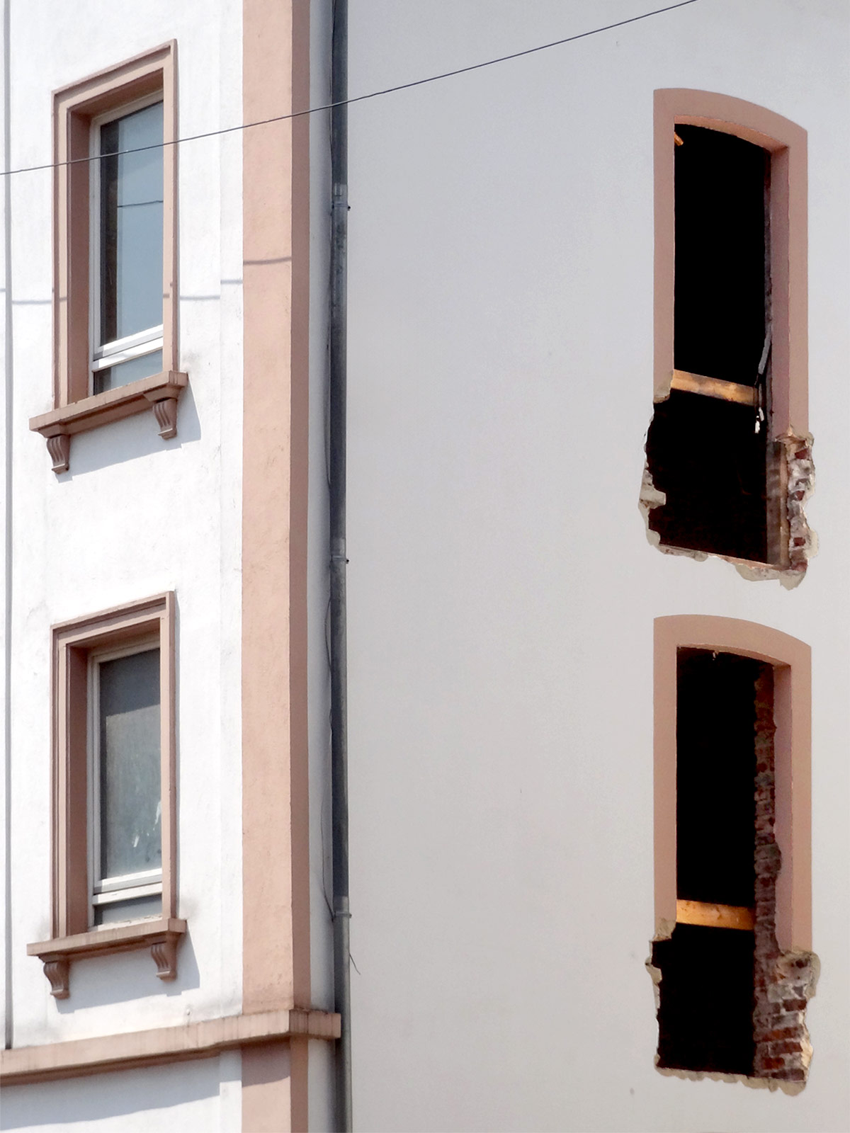 Fassade eine Hauses in Offenbach mit defekten Fensterrahmen