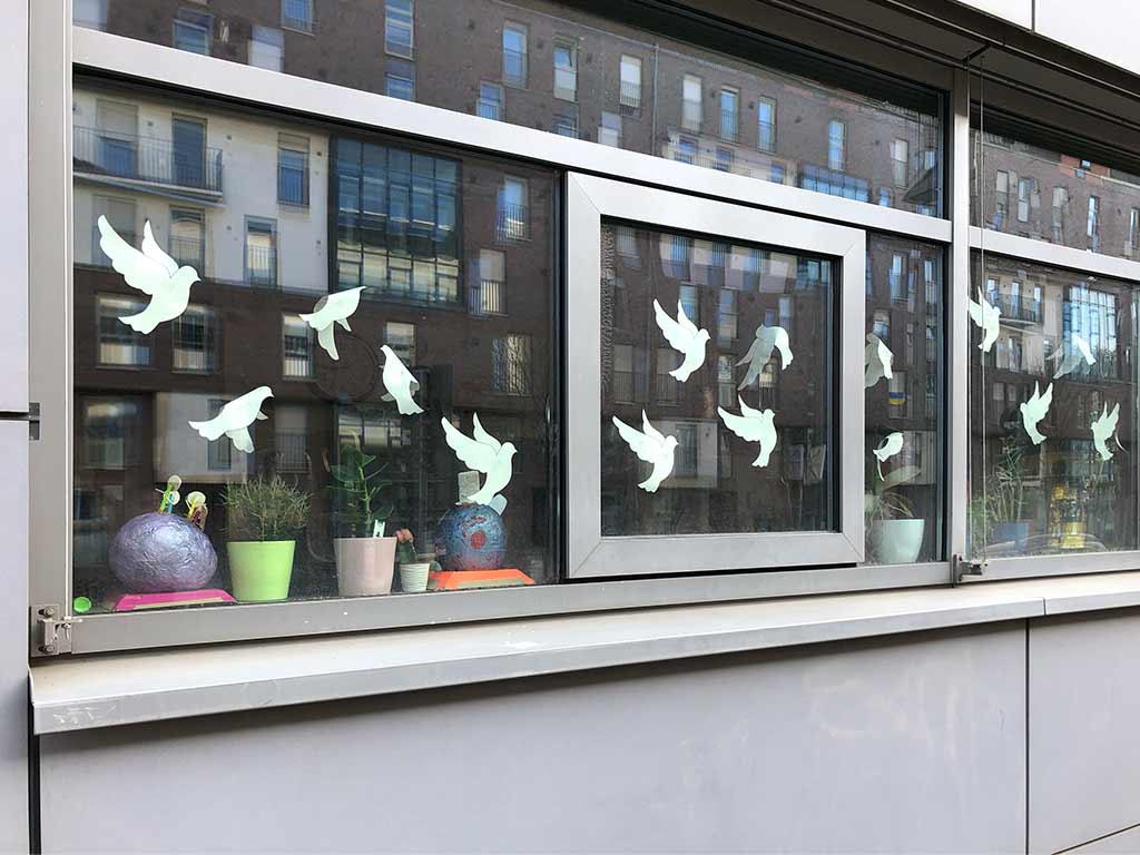 Fensterfront mit Friedenstauben