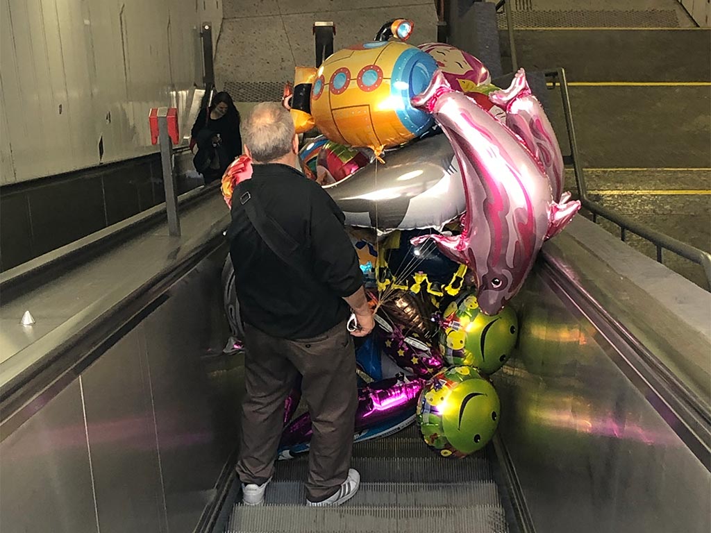 Folienluftballonsverkäufer auf der Rolltreppe am Römer in Frankfurt