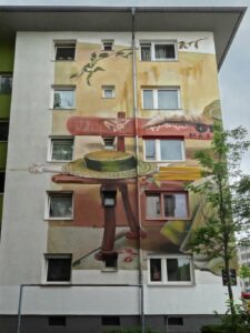 Frau sitzt auf Bank - Großes Graffiti-Wandbild in Offenbach
