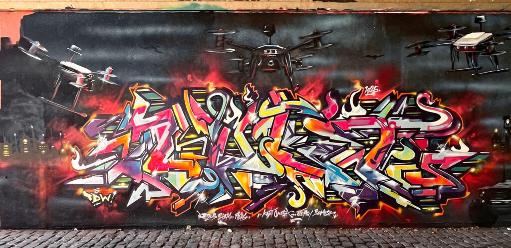 Urban-Art-Wandbild mit Drohnen an der Friedensbrücke in Frankfurt am Main, u. a. mit Kent. (Juni2026)