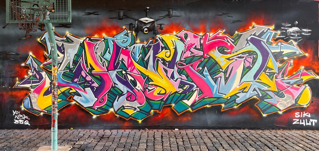 Urban-Art-Wandbild mit Drohnen an der Friedensbrücke in Frankfurt am Main, u. a. mit Kent. (Juni2026)