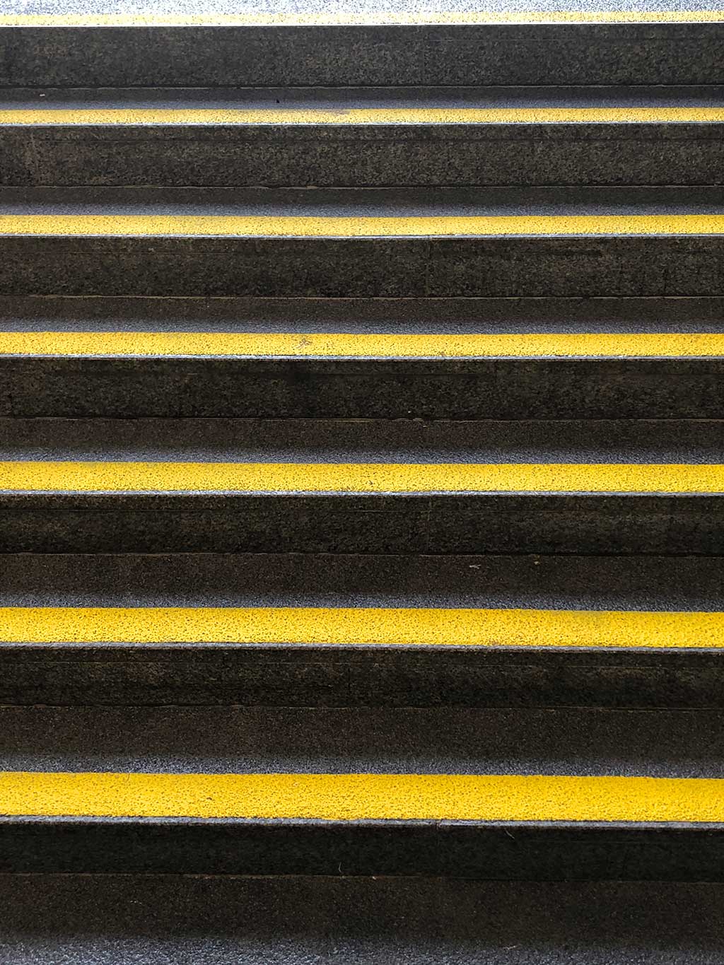 Gelbe Streifen auf grauen Stufen