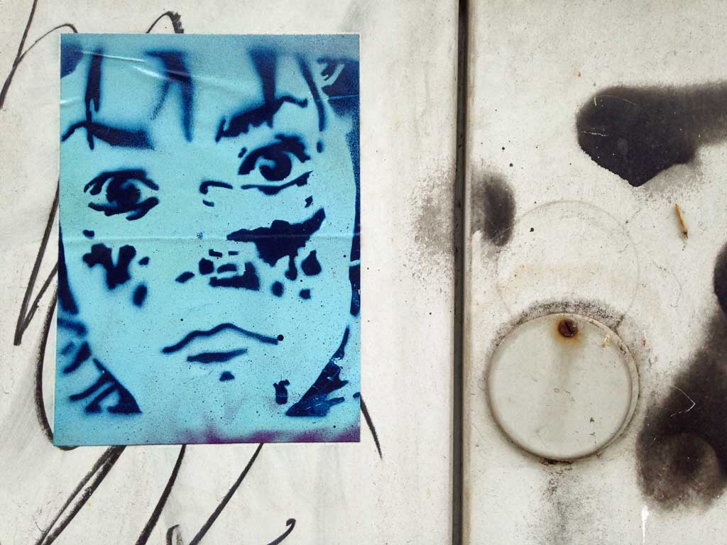 Zweifarbiger Aufkleber mit Schablonengraffiti-Motiv eines Gesichtes