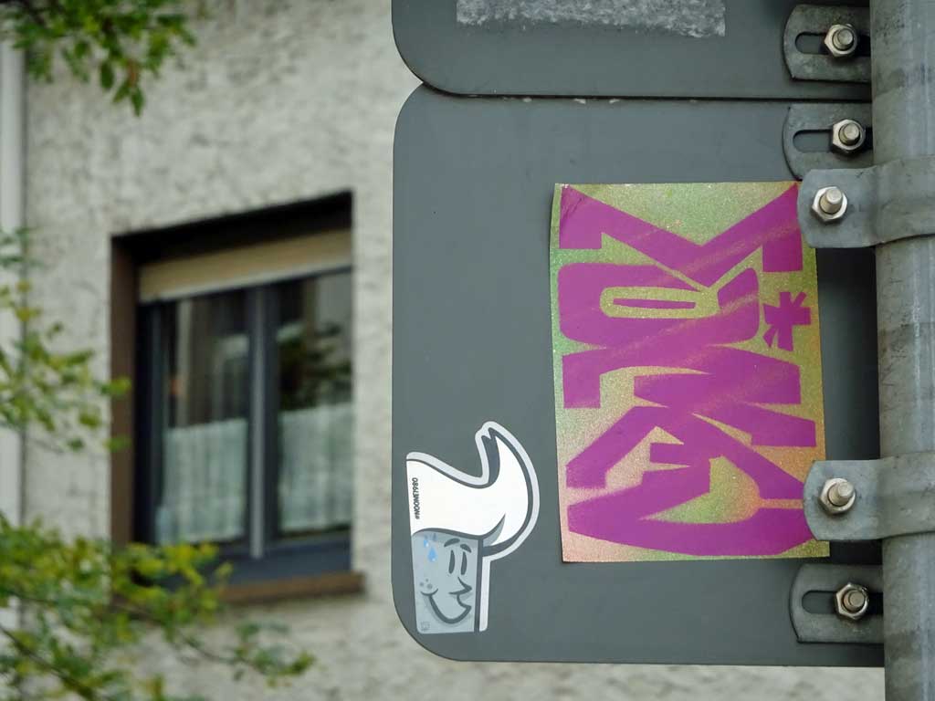 Aufkleber #noone1980 und Stencil des Wortes „Moral“