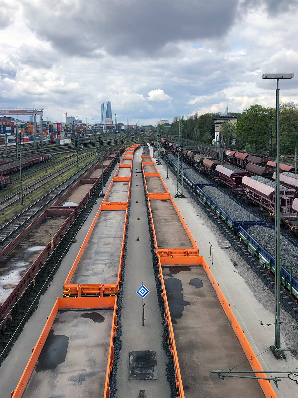 Orangefarbener Frachtzug fährt durch Frankfurt