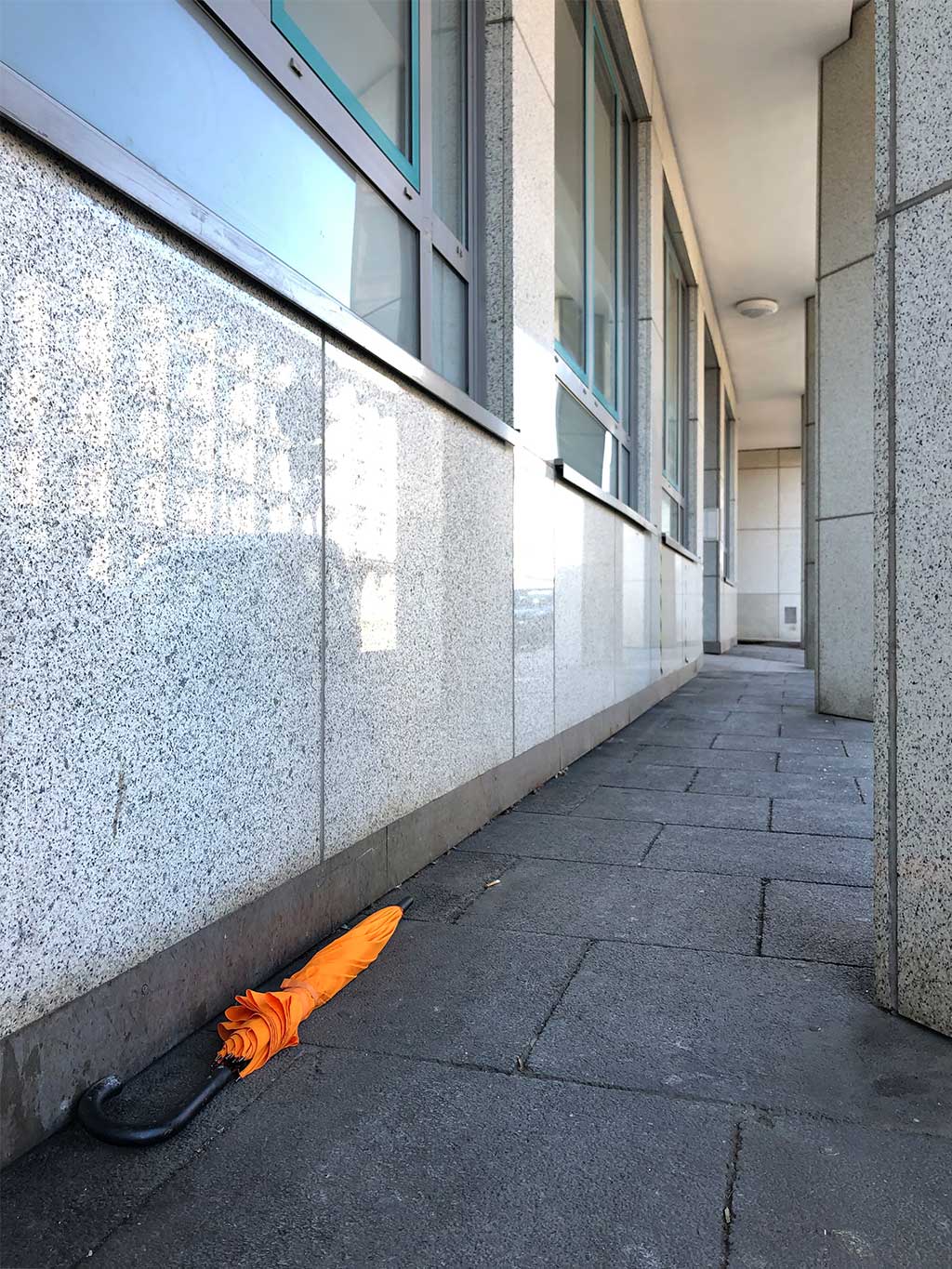 Orangefarbener Schirm auf dem Boden in Frankfurt