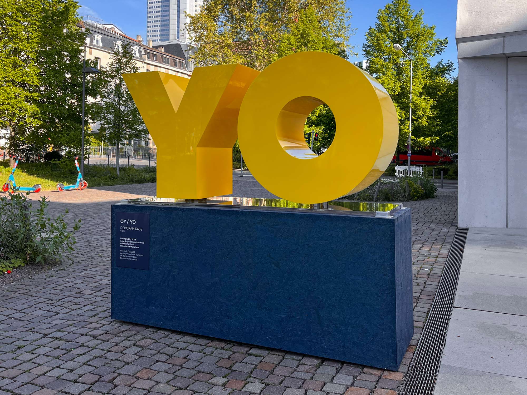 Gelbe Buchstaben auf blauem Podest – OY / YO von Deborah Kass vor dem Jüdischen Museum Frankfurt