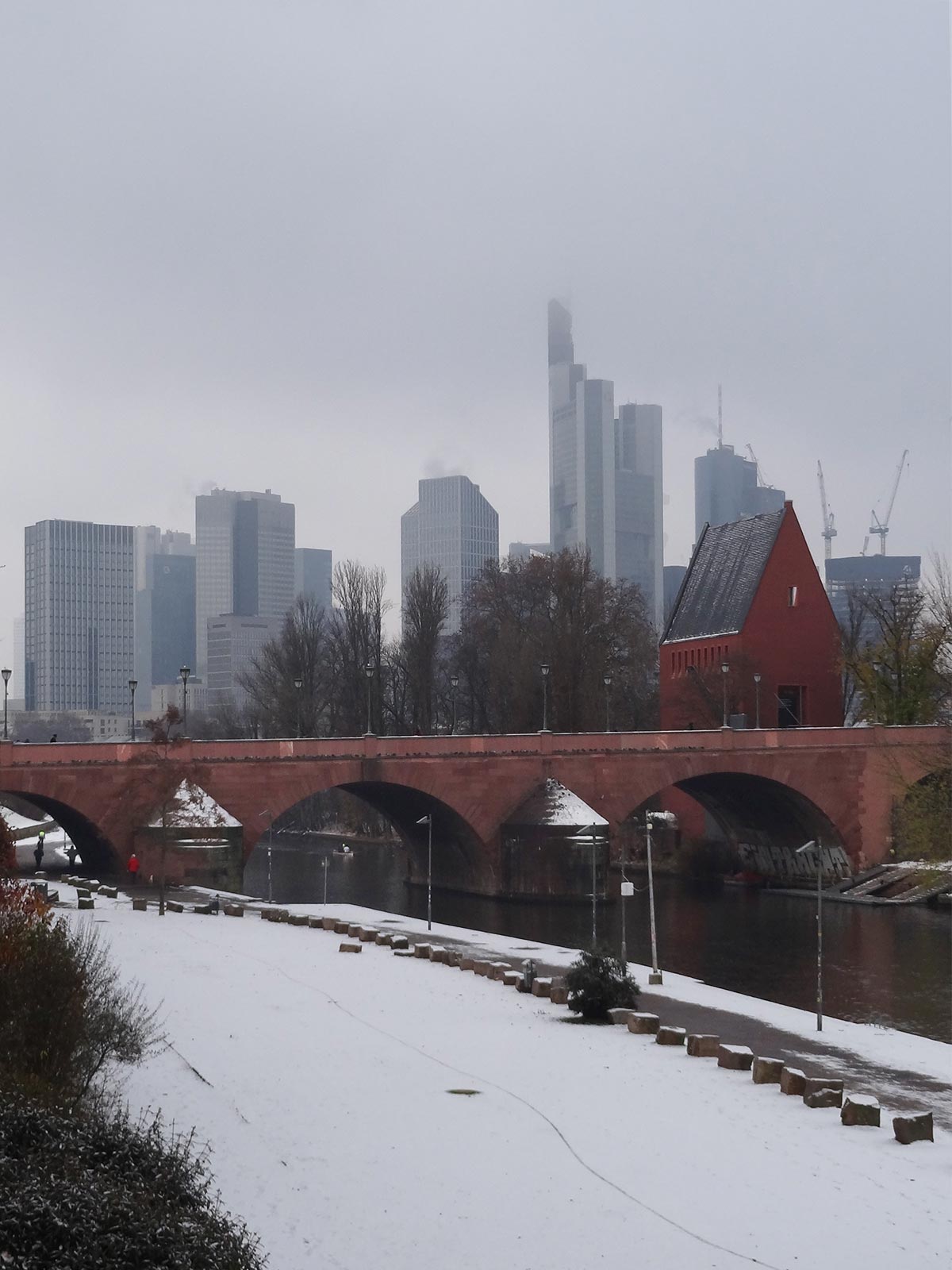 Skyline und Portikus und Alte Brücke in Frankfurt mit Schnee