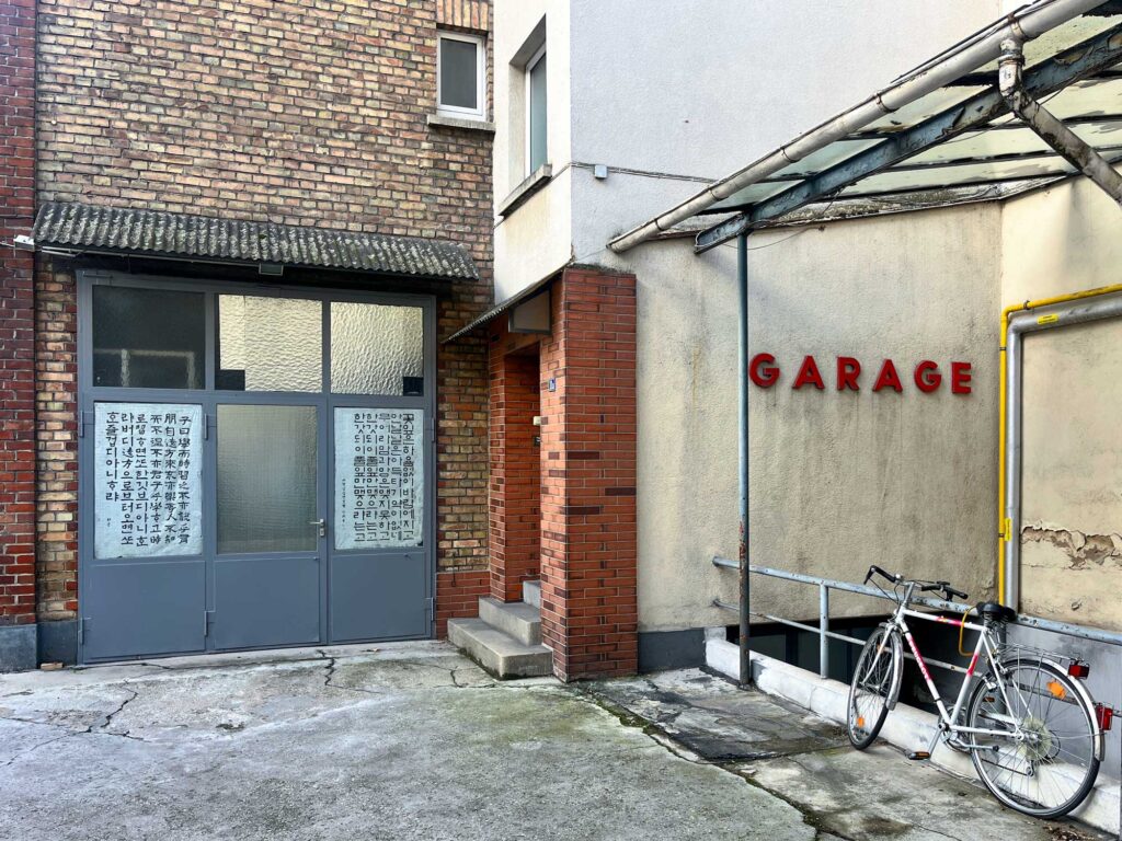 Hinterhof im Frankfurter Gallus mit Schriftzug GARAGE und asiatische Schriftzeichen an Türen