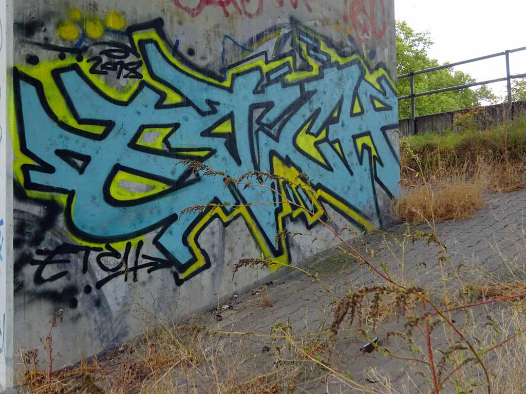 Dreifarbiges Stylewriting an einem Betonpfeiler