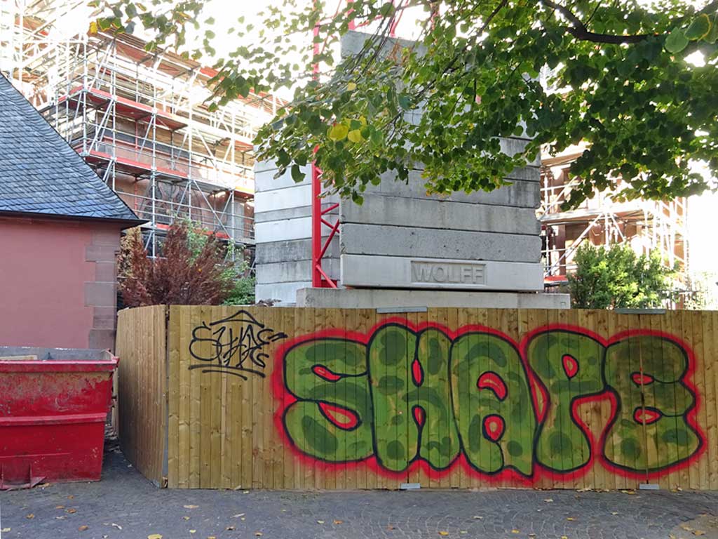 Graffiti an einem Holzbauzaun