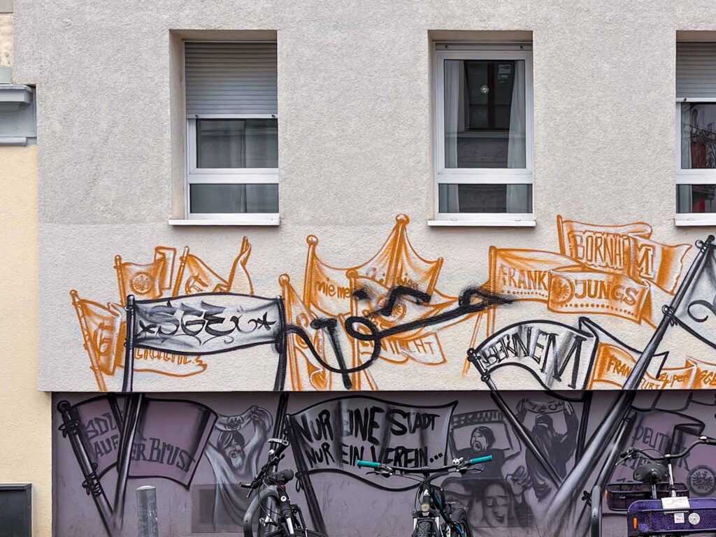 Wände im Wandel – Übermalte Murals und Wandbilder in der Urban Art, hier: übersprüht mit politischem Zeichen.