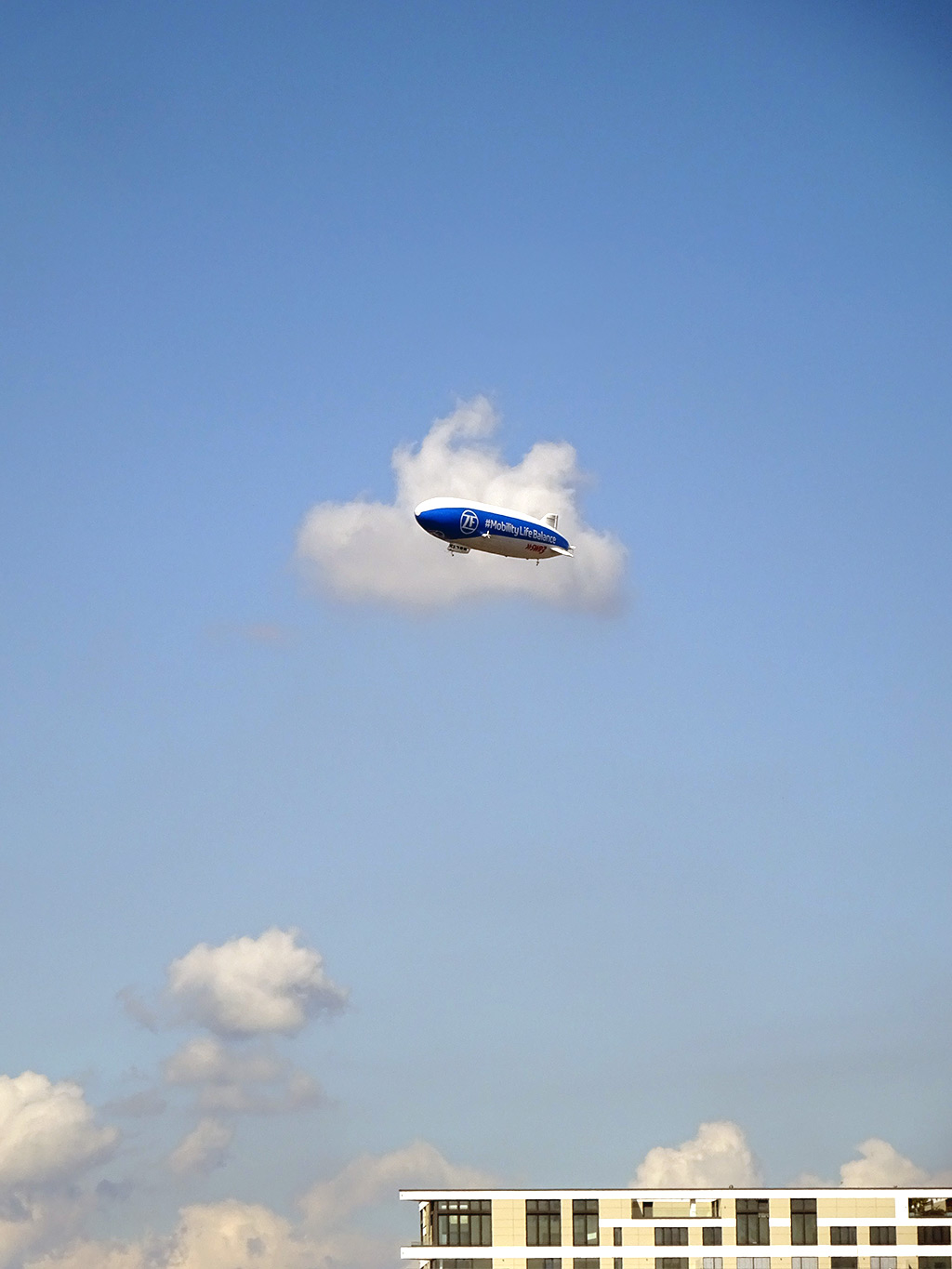 Blau-weißer Zeppelin fliegt über Frankfurt